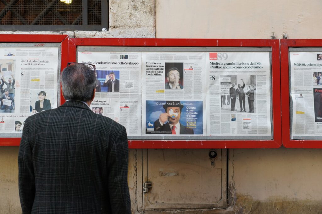 man reading newspaper in bulletin board