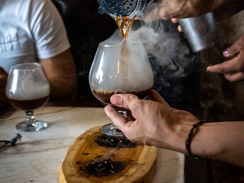 a person pours a beverage into a glass